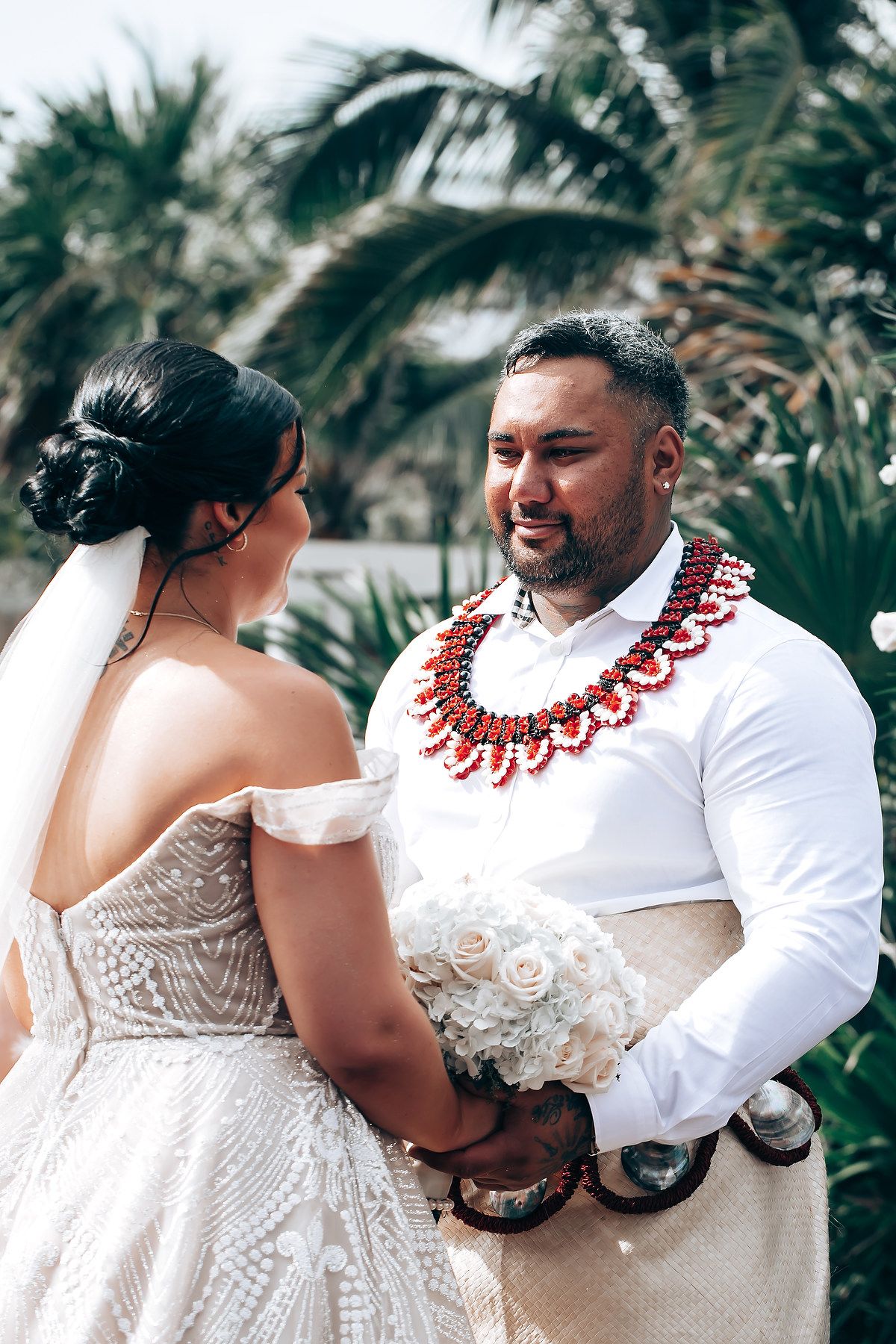 A couple shares an intimate moment during their tropical wedding celebration.