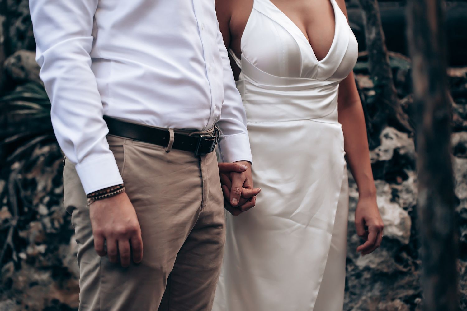 A romantic outdoor photoshoot in a natural setting with white attire and khaki pants.