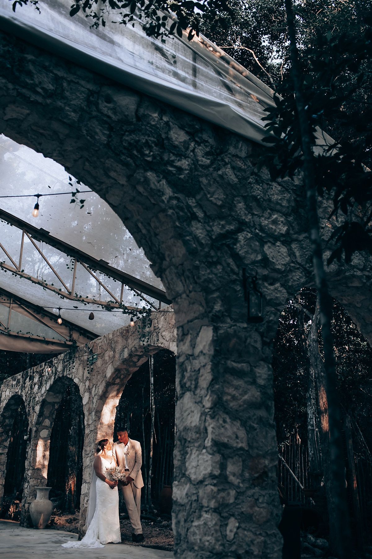Wedding ceremony photos in a rustic stone venue with romantic ambient lighting.