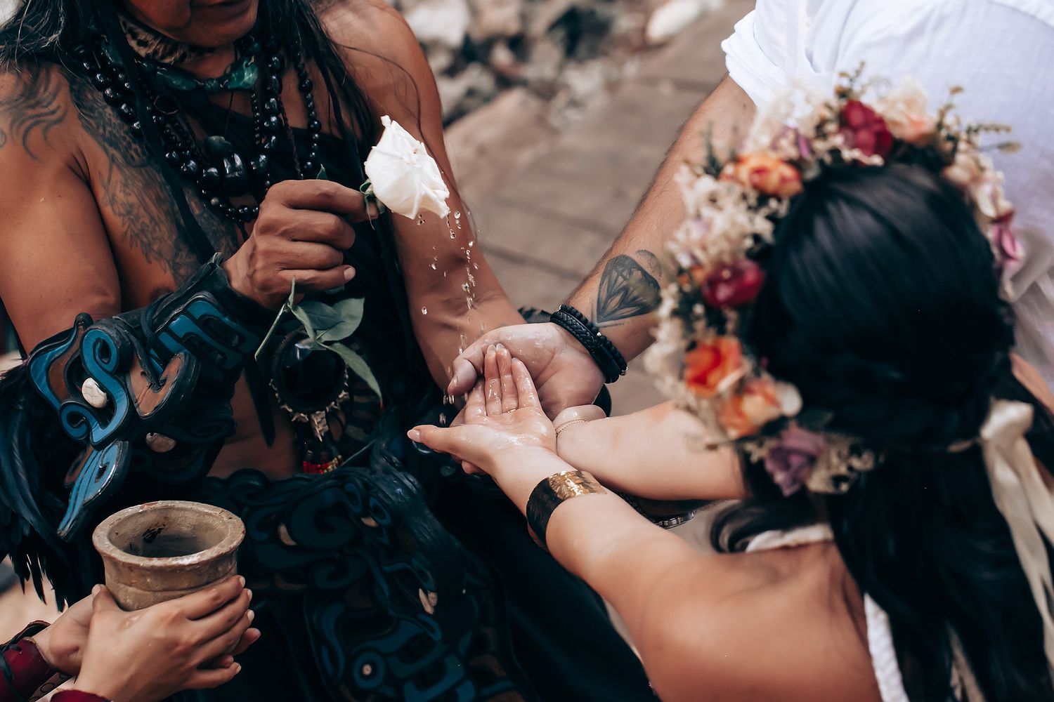 Traditional ritual participants interact during an outdoor spiritual ceremony.