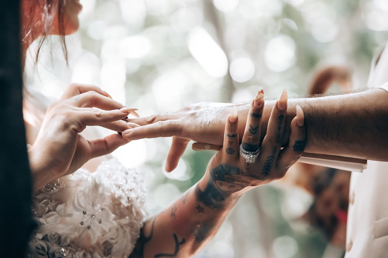 Hands reaching out to exchange rings during an intimate wedding ceremony.