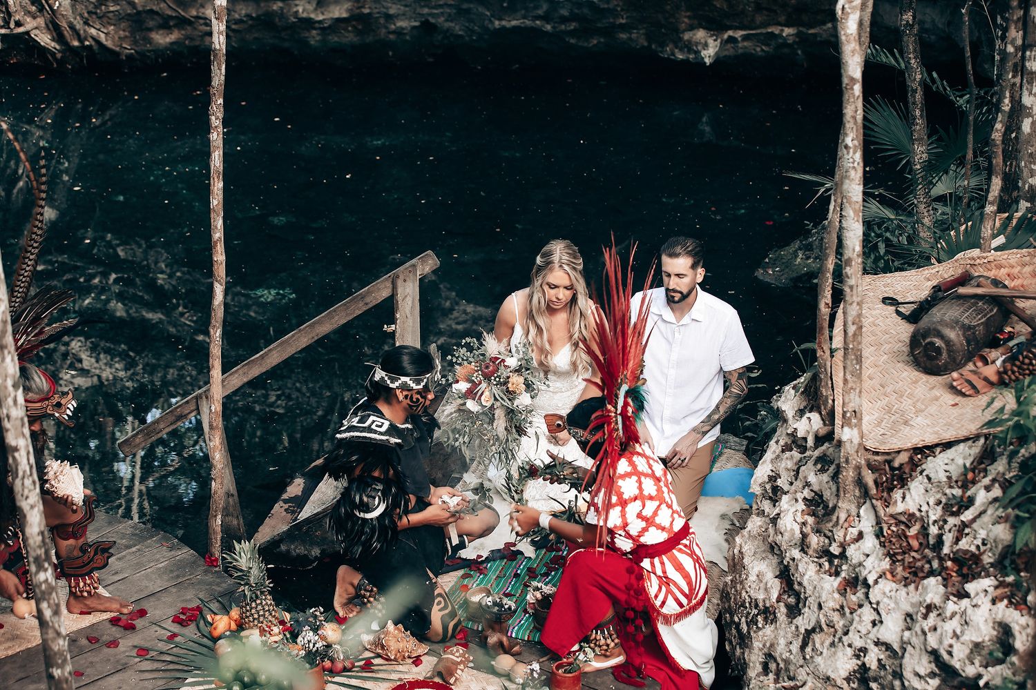 Couple standing in a lush forest setting during what appears to be an intimate ceremony or photoshoot.