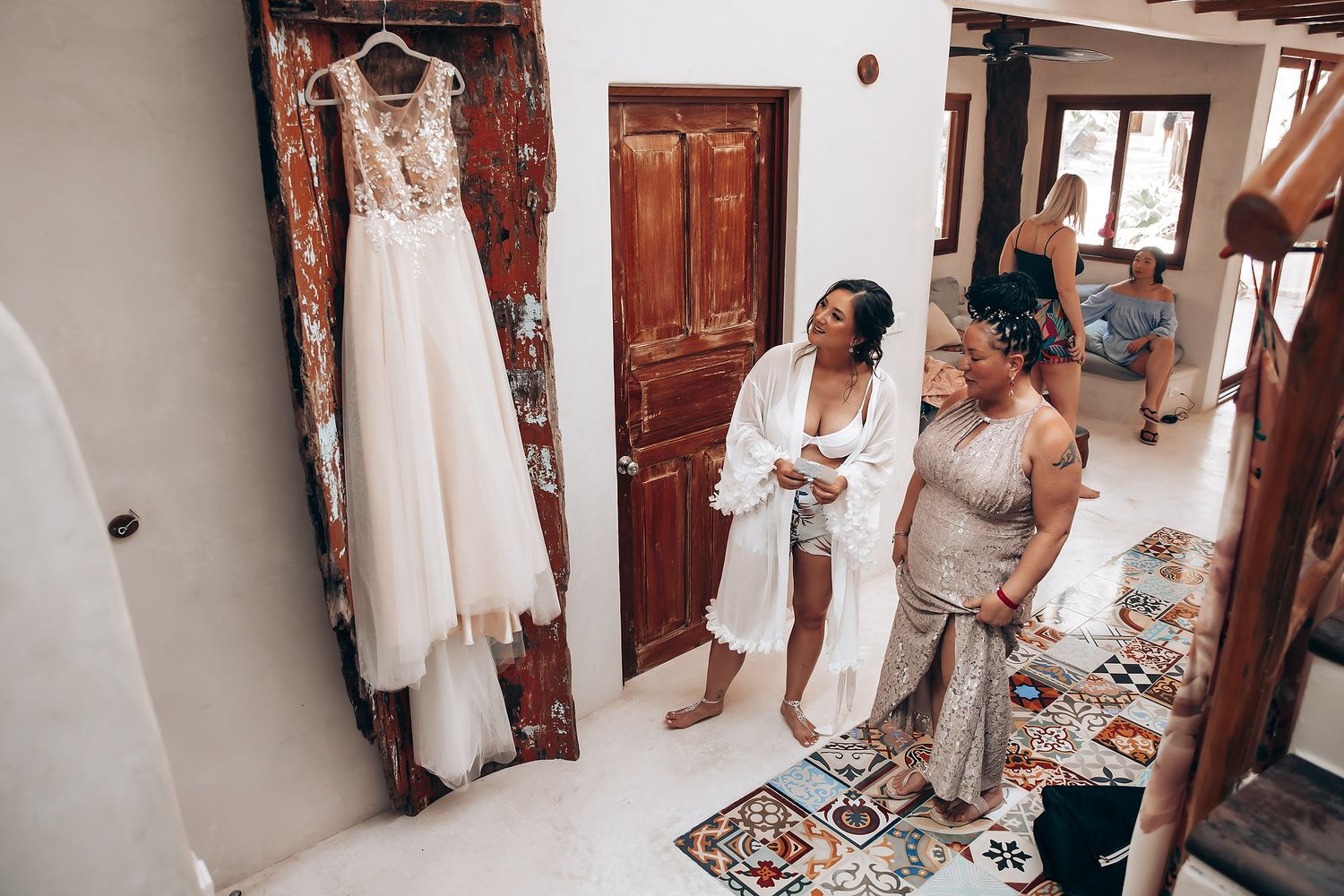 Wedding preparations in a rustic room with white walls and wooden doors.