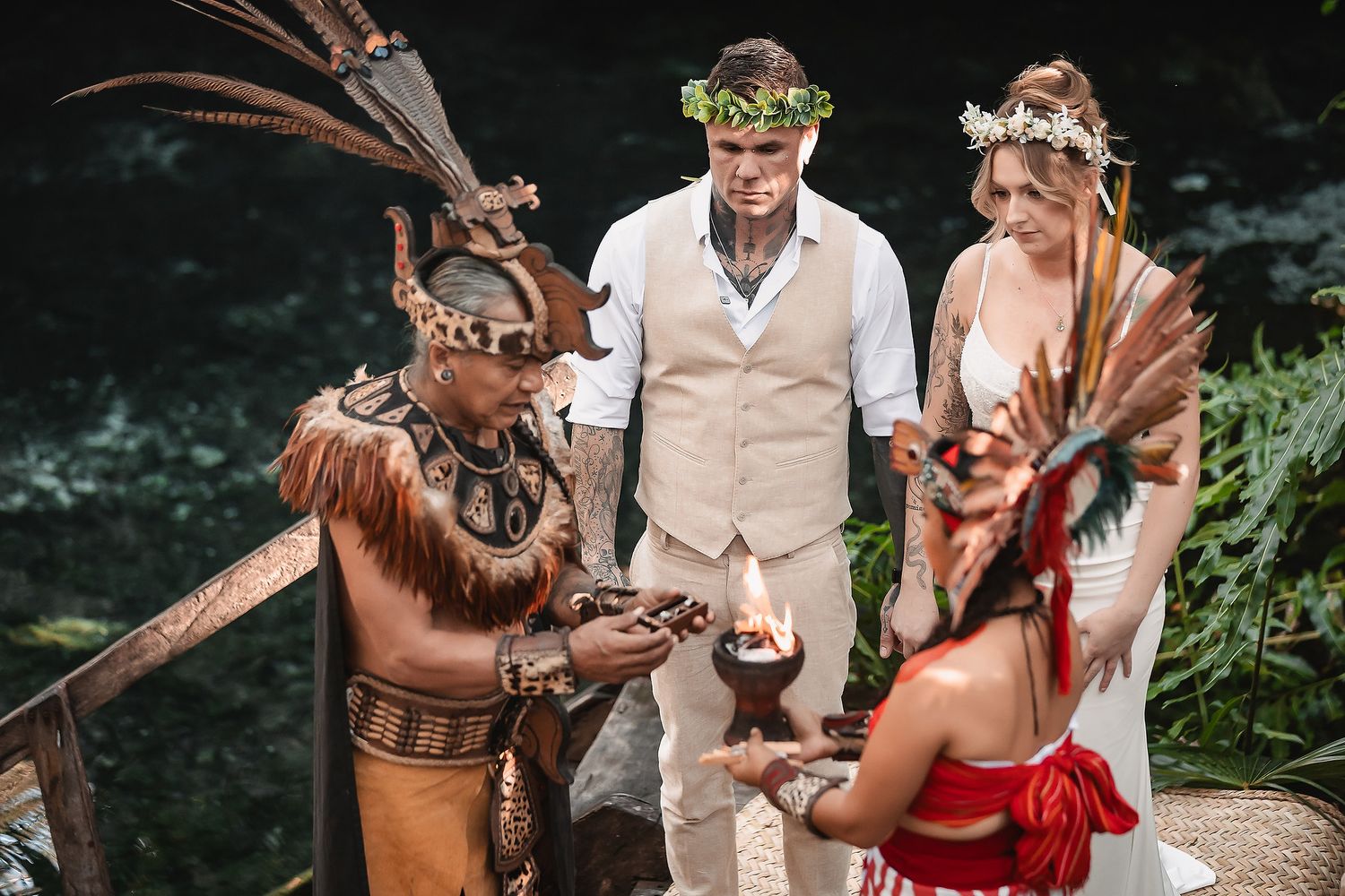 Couple exchanges vows in traditional Mayan wedding ceremony with indigenous officiant in tropical jungle setting.