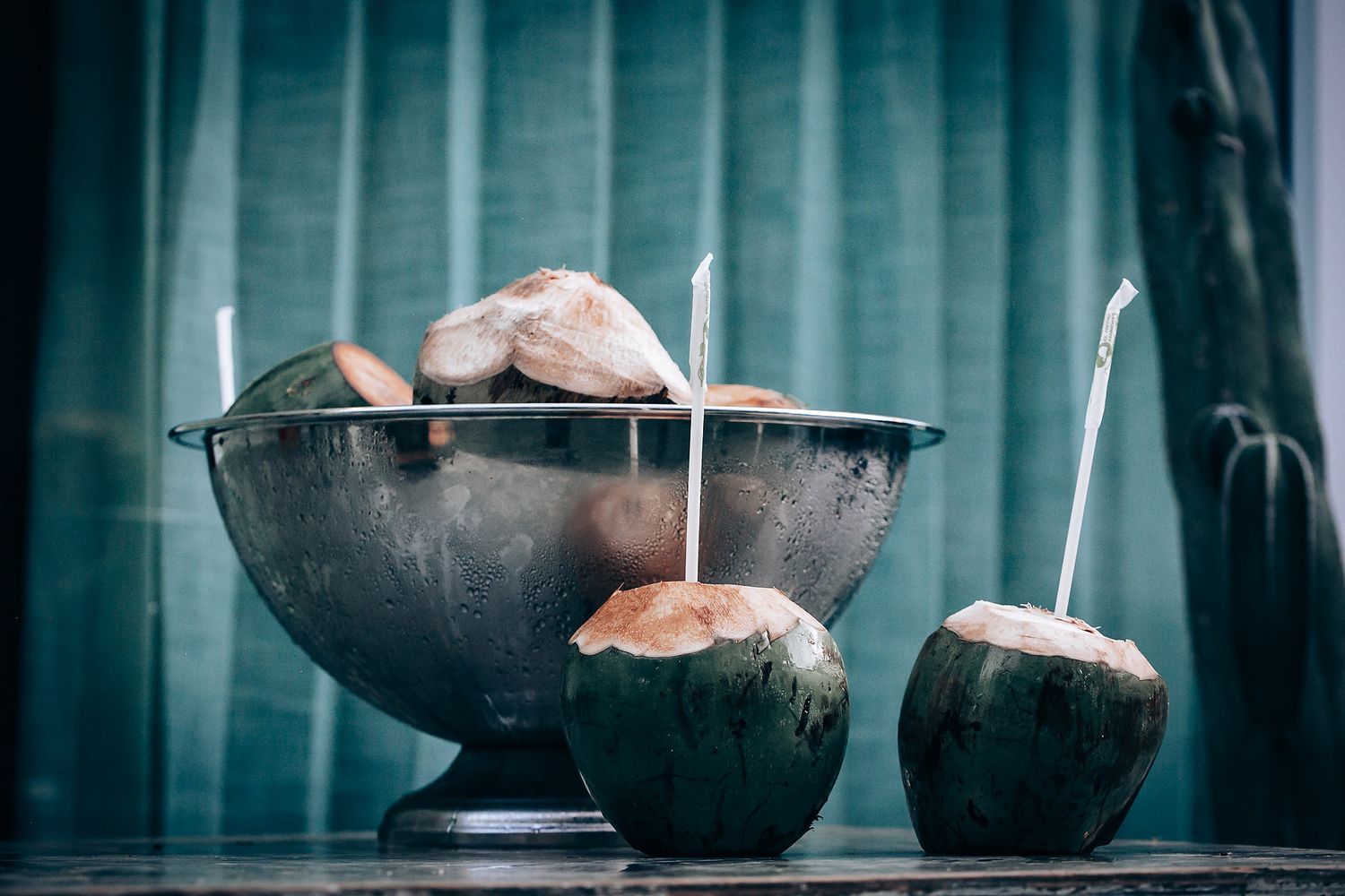 Dark ceramic bowls arranged on a moody blue-tinted surface with dramatic lighting.