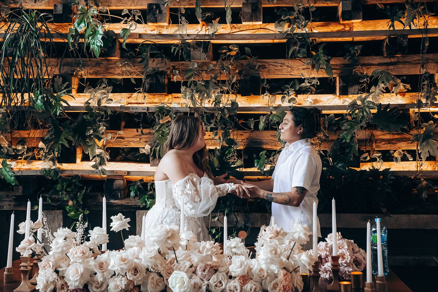 Wedding reception space with hanging floral arrangements and wooden architectural elements.
