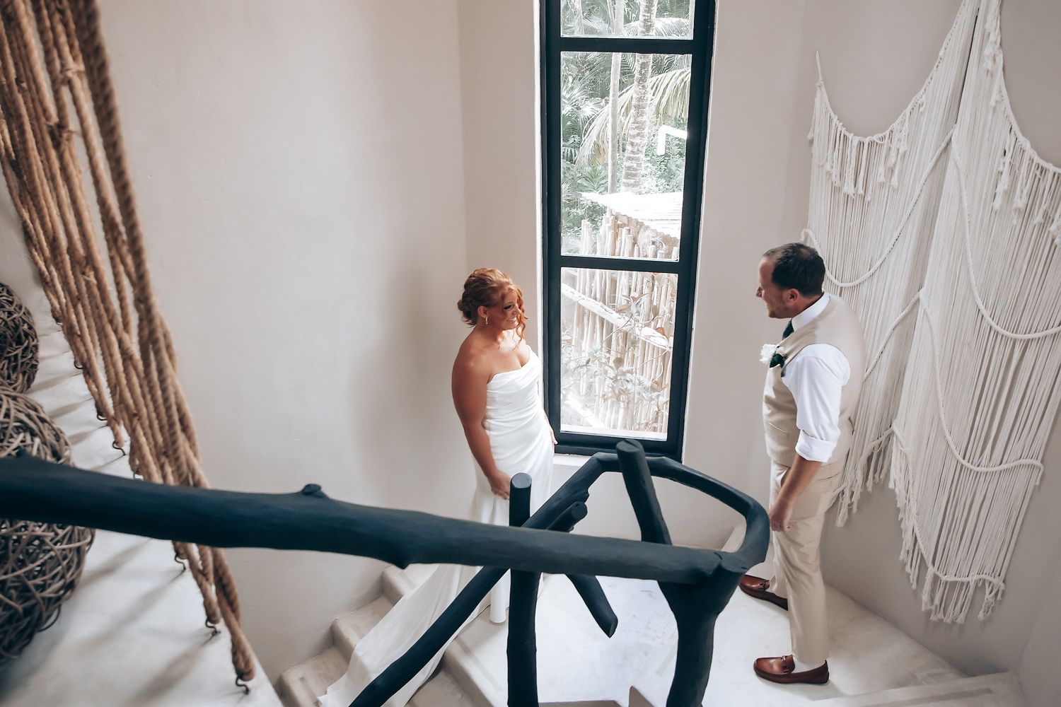 Interior of tropical resort room with arched windows and natural decor.