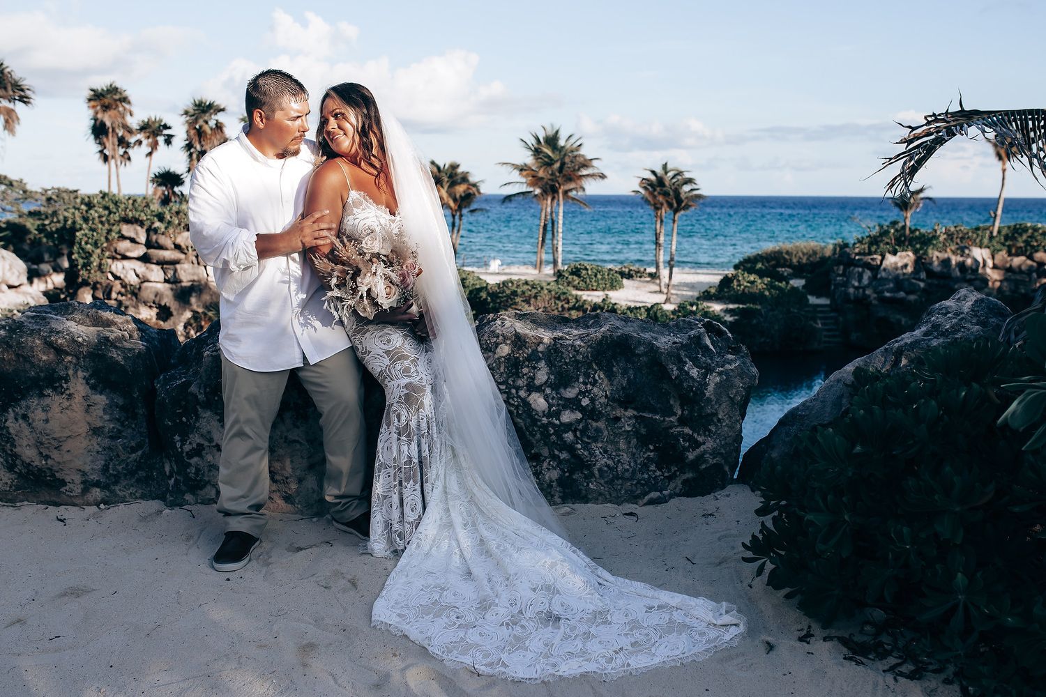 Bride and groom walking through tropical gardens at Xcaret Resort
