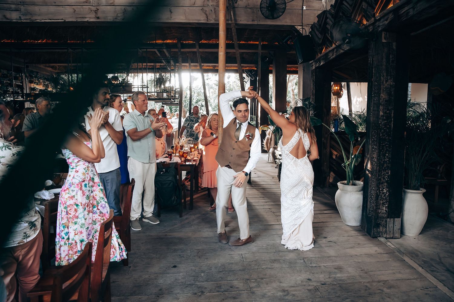 Wedding party dances and celebrates on an outdoor patio during a lively reception.