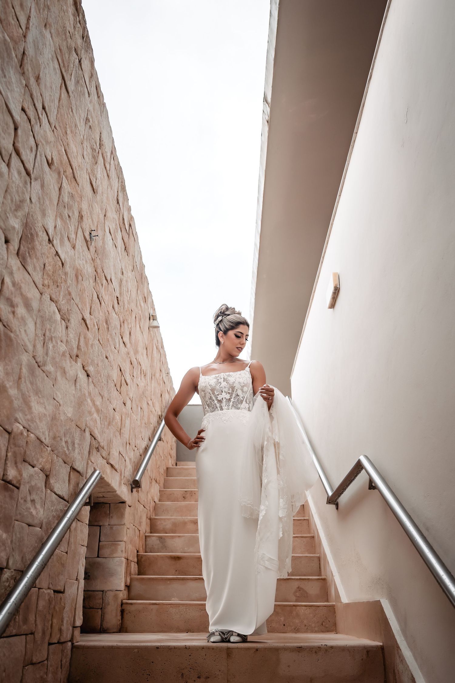 Sequential shots of a bride walking down rustic stone stairs in her wedding gown.