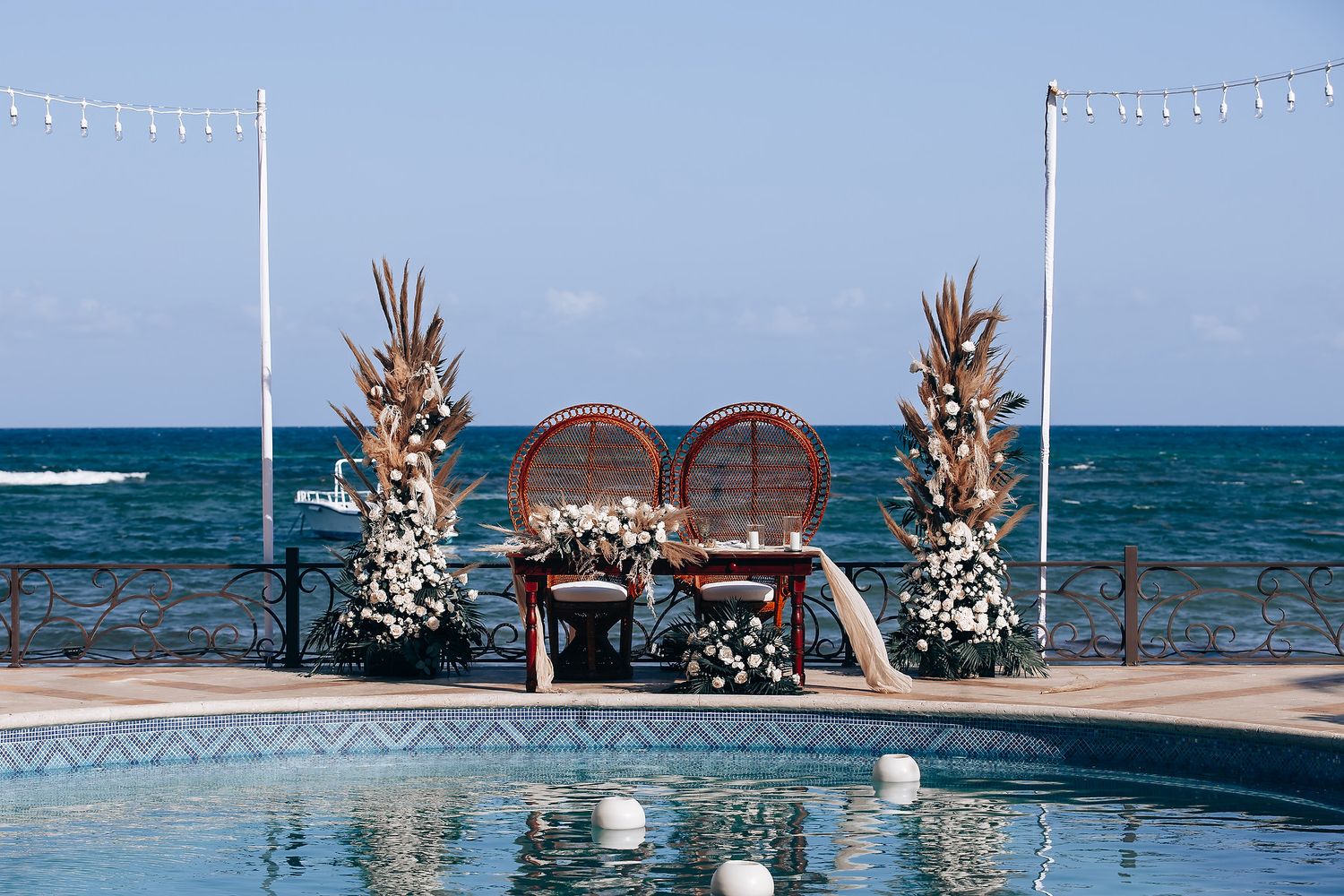 Elegant beach wedding ceremony setup with white floral arrangements and ocean views.