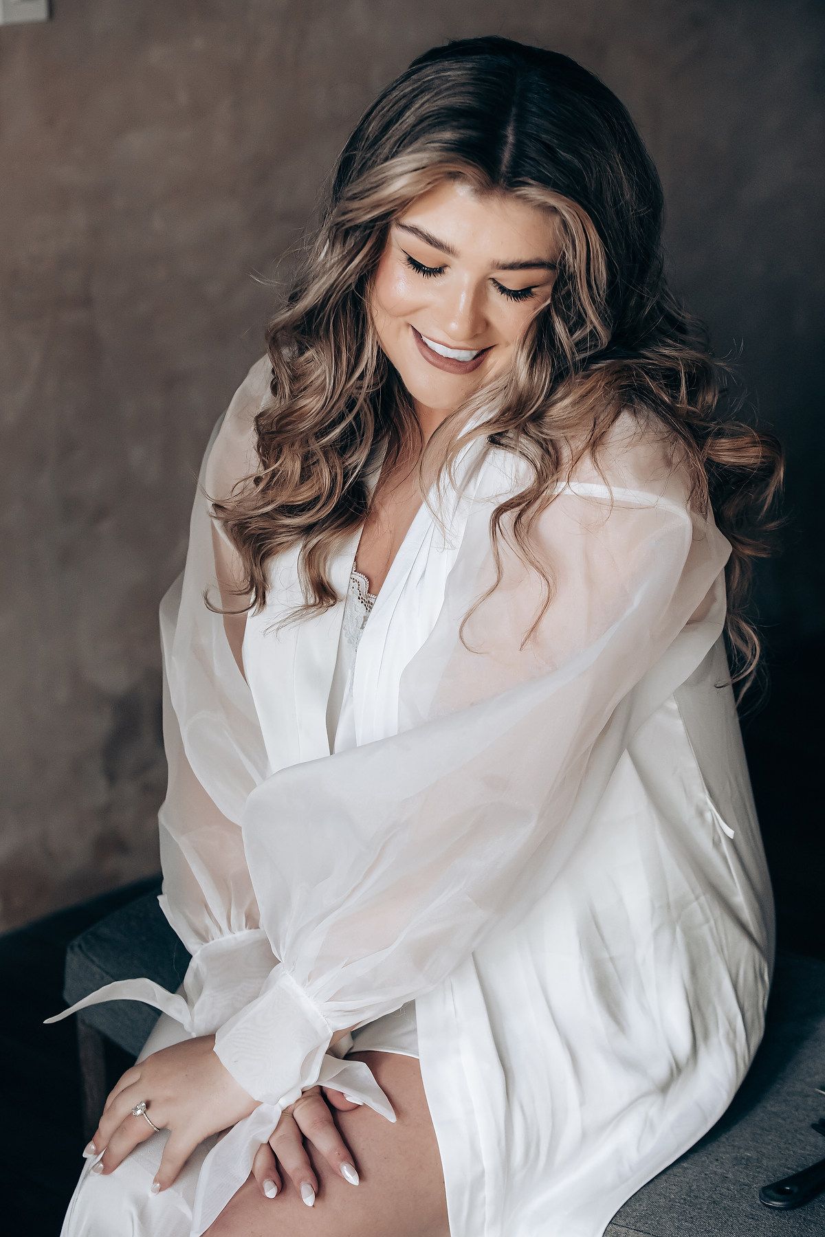 Getting ready scene with flowing white silk robe in moody lighting.