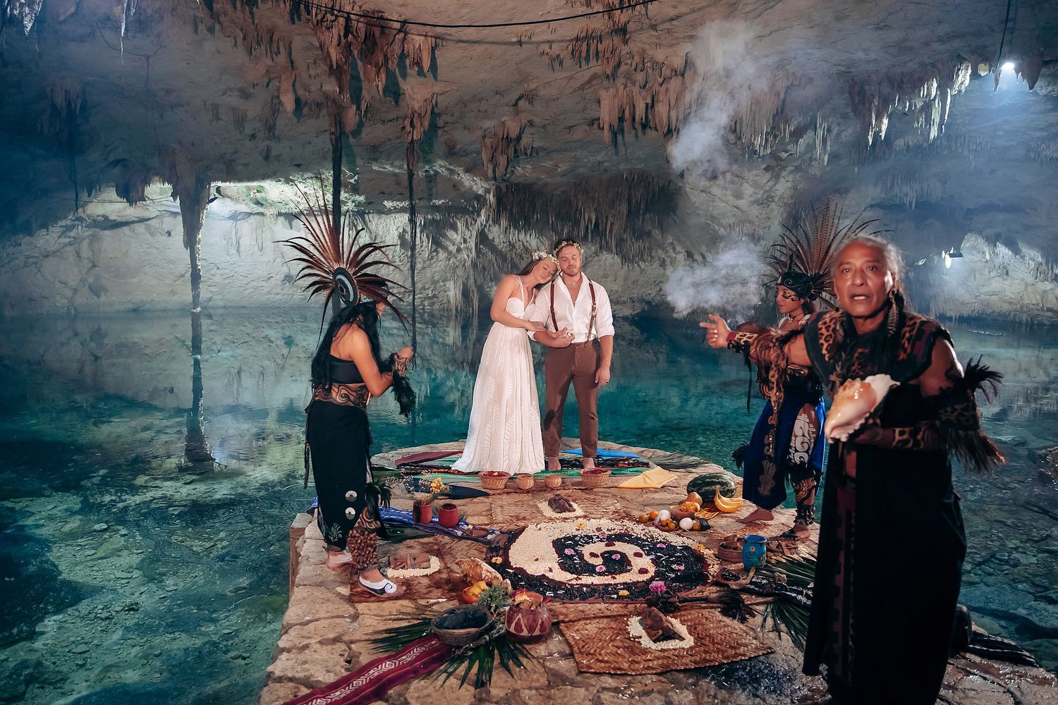 A series of moody wedding photos showing couples and decor in a misty cave-like setting with romantic lighting and details.