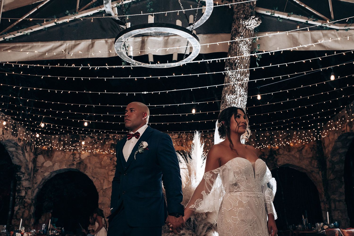 Wedding reception venue decorated with twinkling string lights and rustic brick walls creating a magical atmosphere.