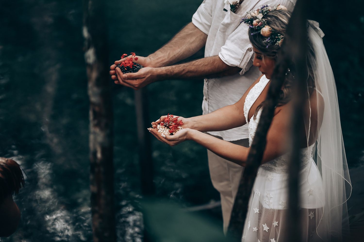 White-clad figures stand together in a moody forest clearing with dramatic lighting.