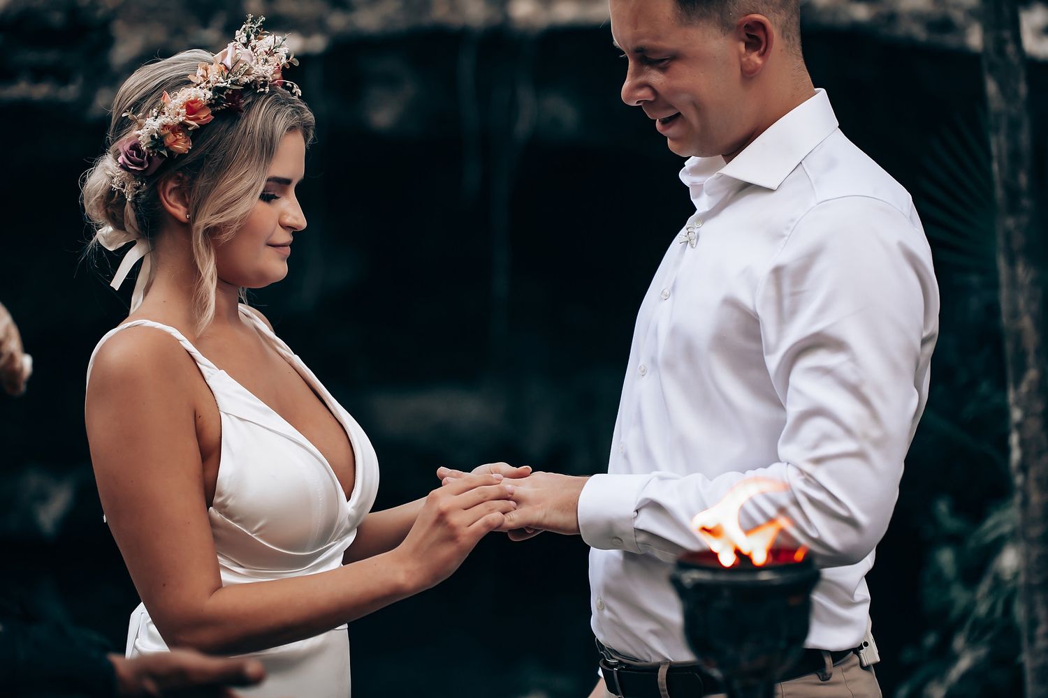 Couple dancing together in an outdoor forest setting with romantic lighting and natural surroundings.