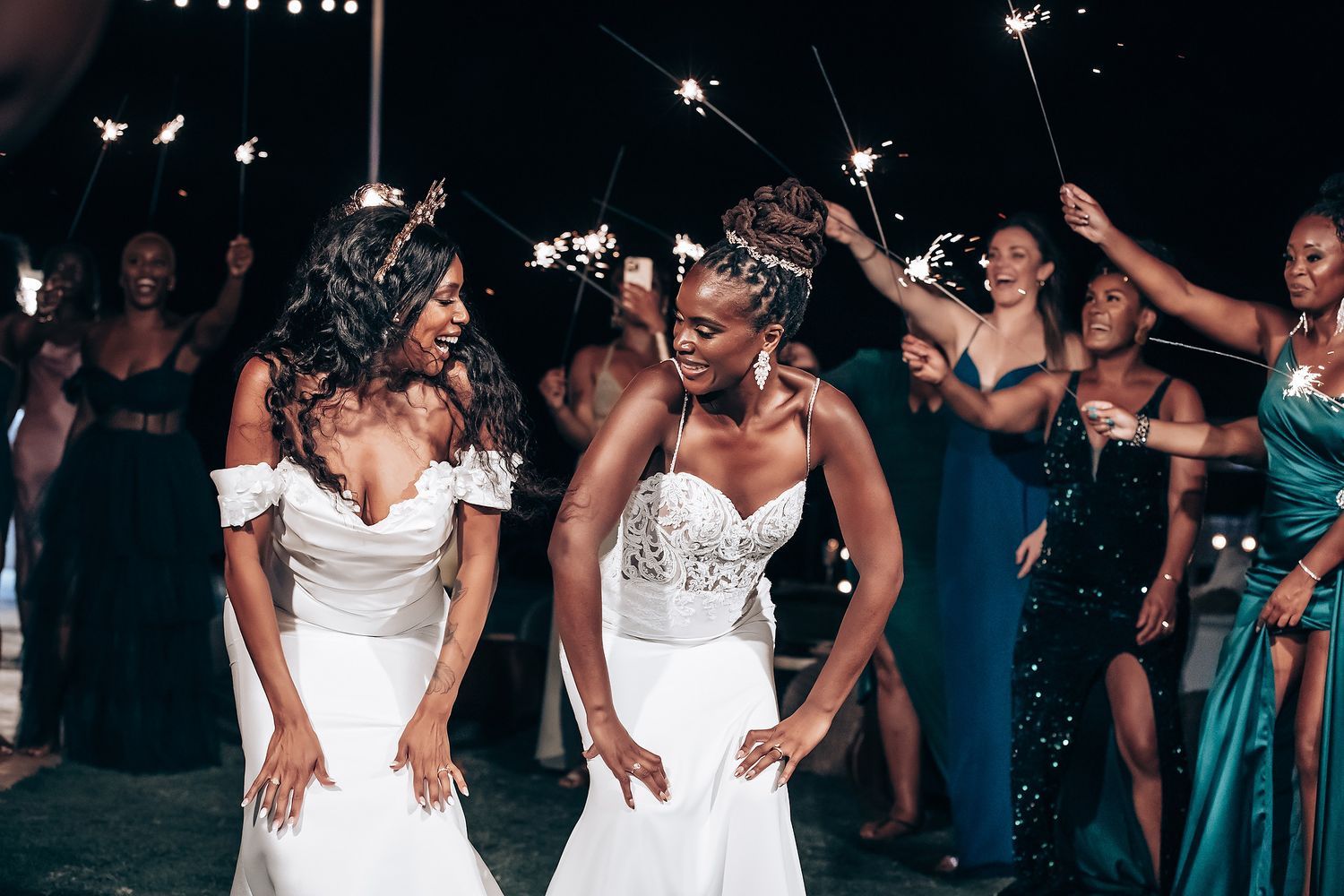 Nighttime wedding celebration with guests holding sparklers in a festive atmosphere.