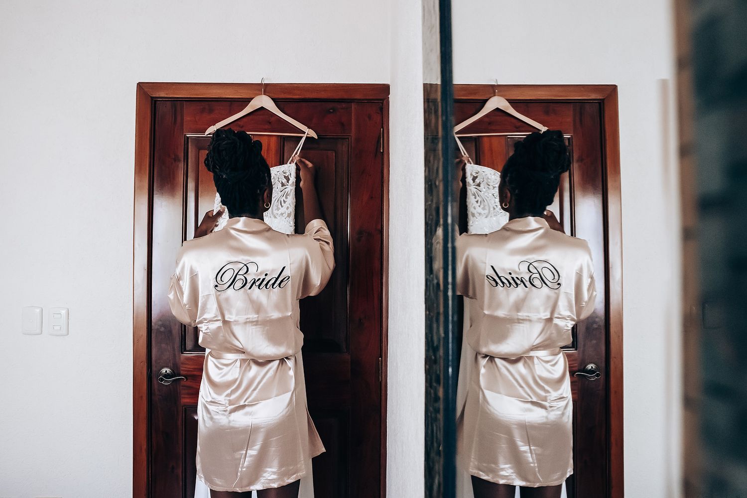 White hangers arranged symmetrically on wooden closet doors in a minimalist setting.