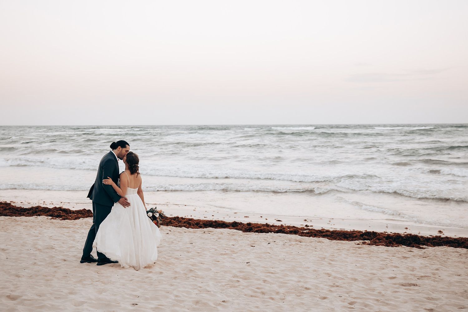 Couple sharing a romantic moment on a serene beach at dusk.