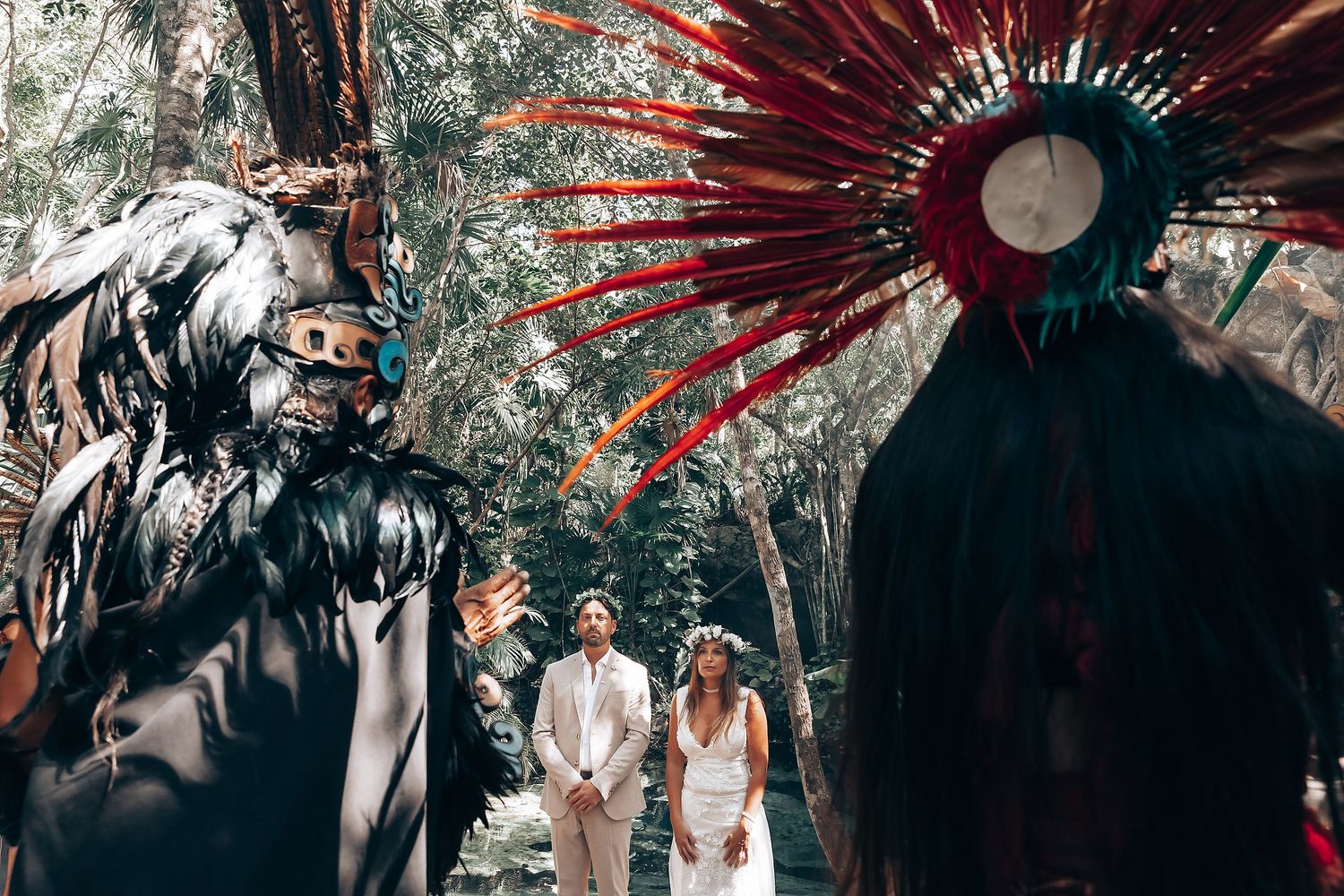 Dramatic wedding scene with silhouetted figures against lush greenery and red feathered headdress accents in multiple frames.