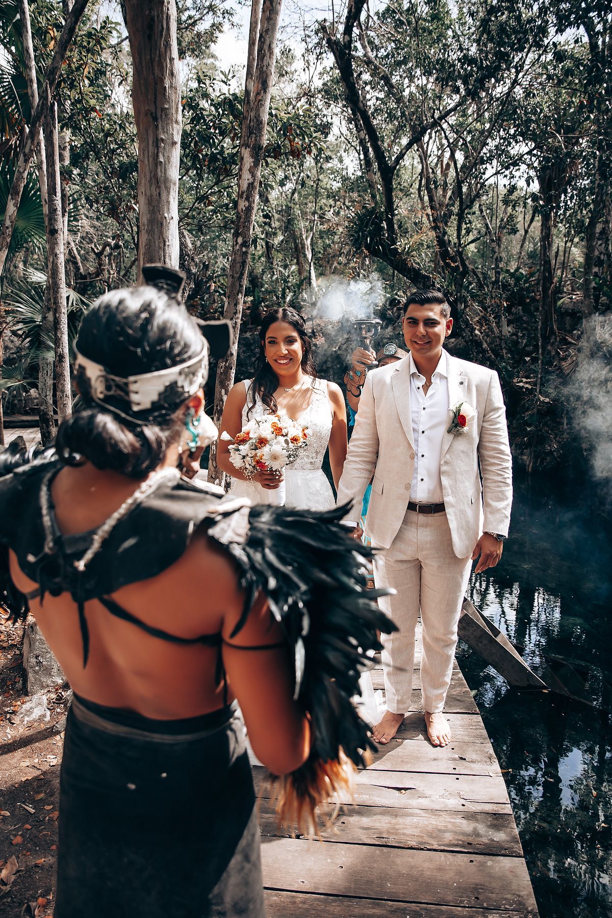 A wedding ceremony in a wooded setting with guests watching the couple exchange vows.