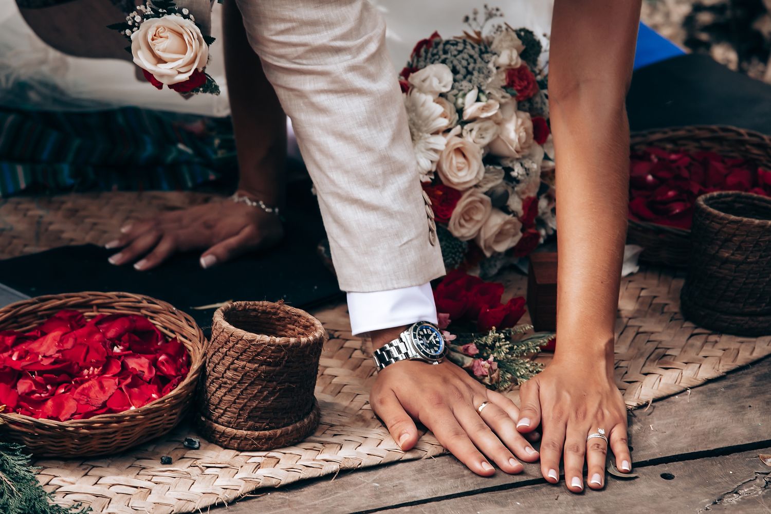 Wedding details showing bouquets, rose petals, and decorative elements on wooden surfaces.