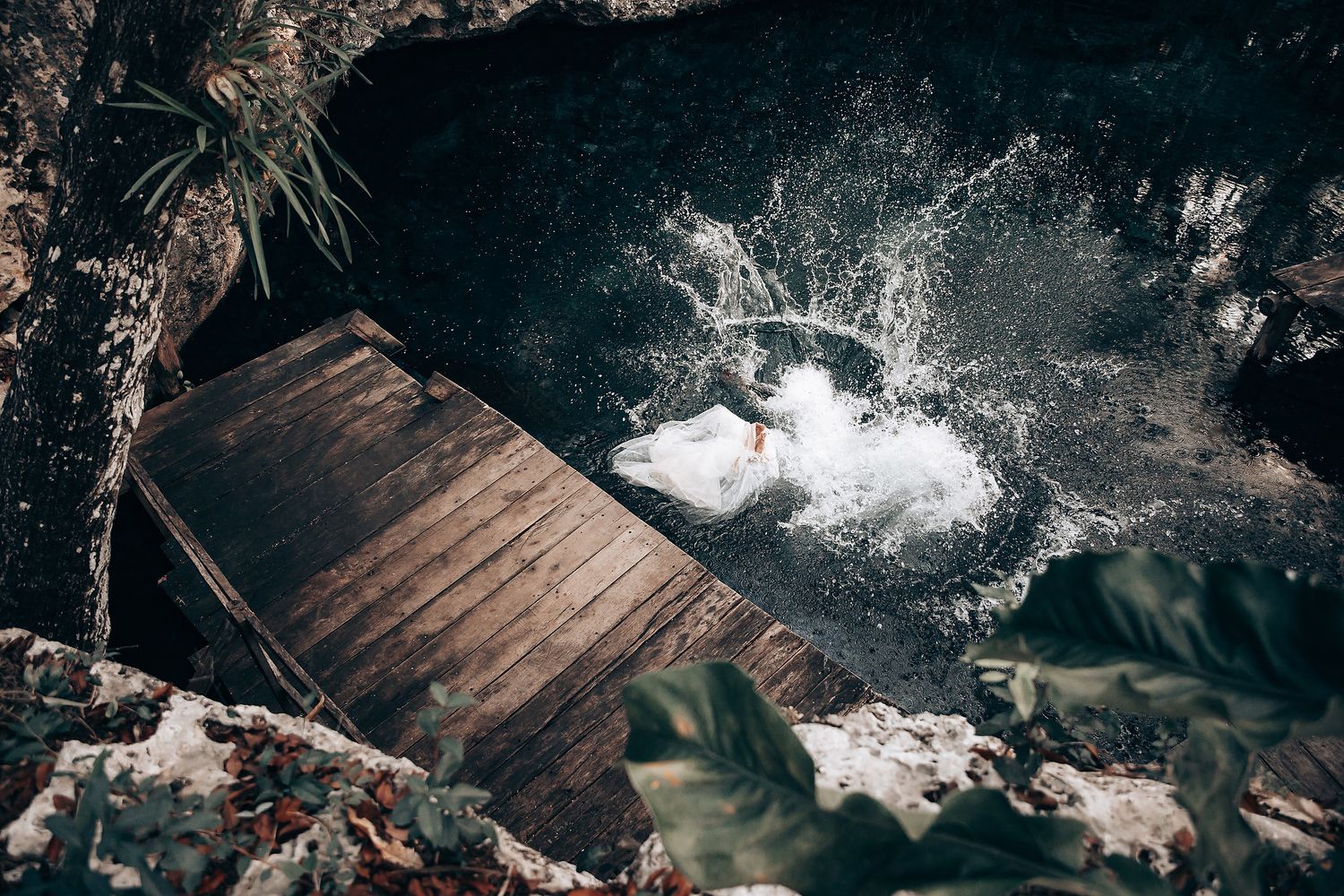 Water splashes create magical moments during an underground cenote cave wedding celebration.