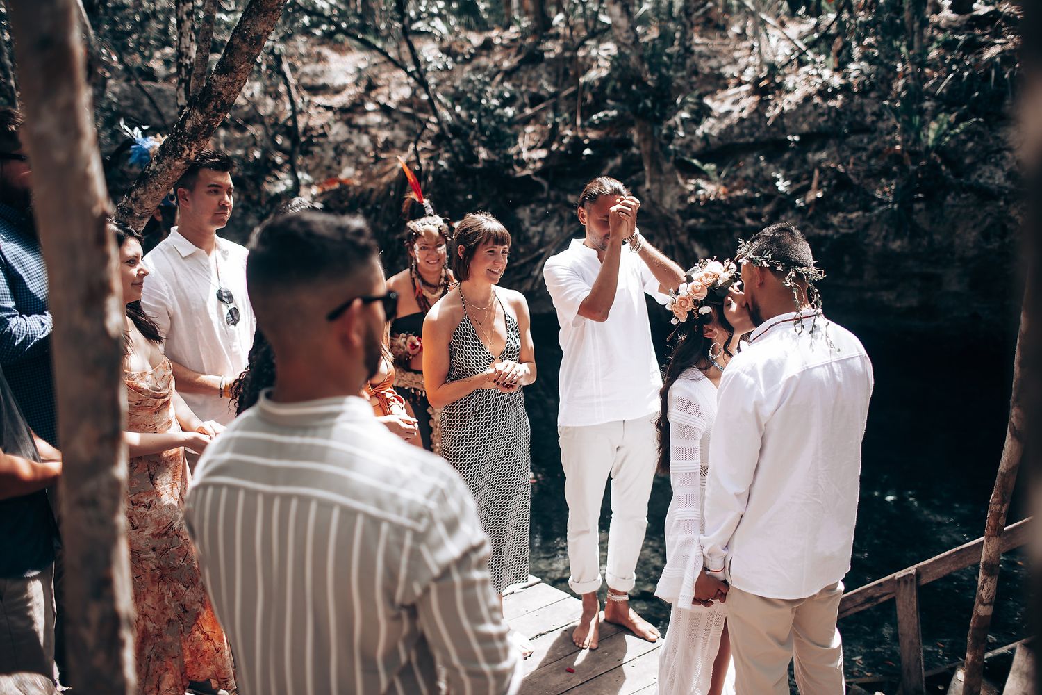 Group of people in white clothing gathered for an outdoor ceremonial event.