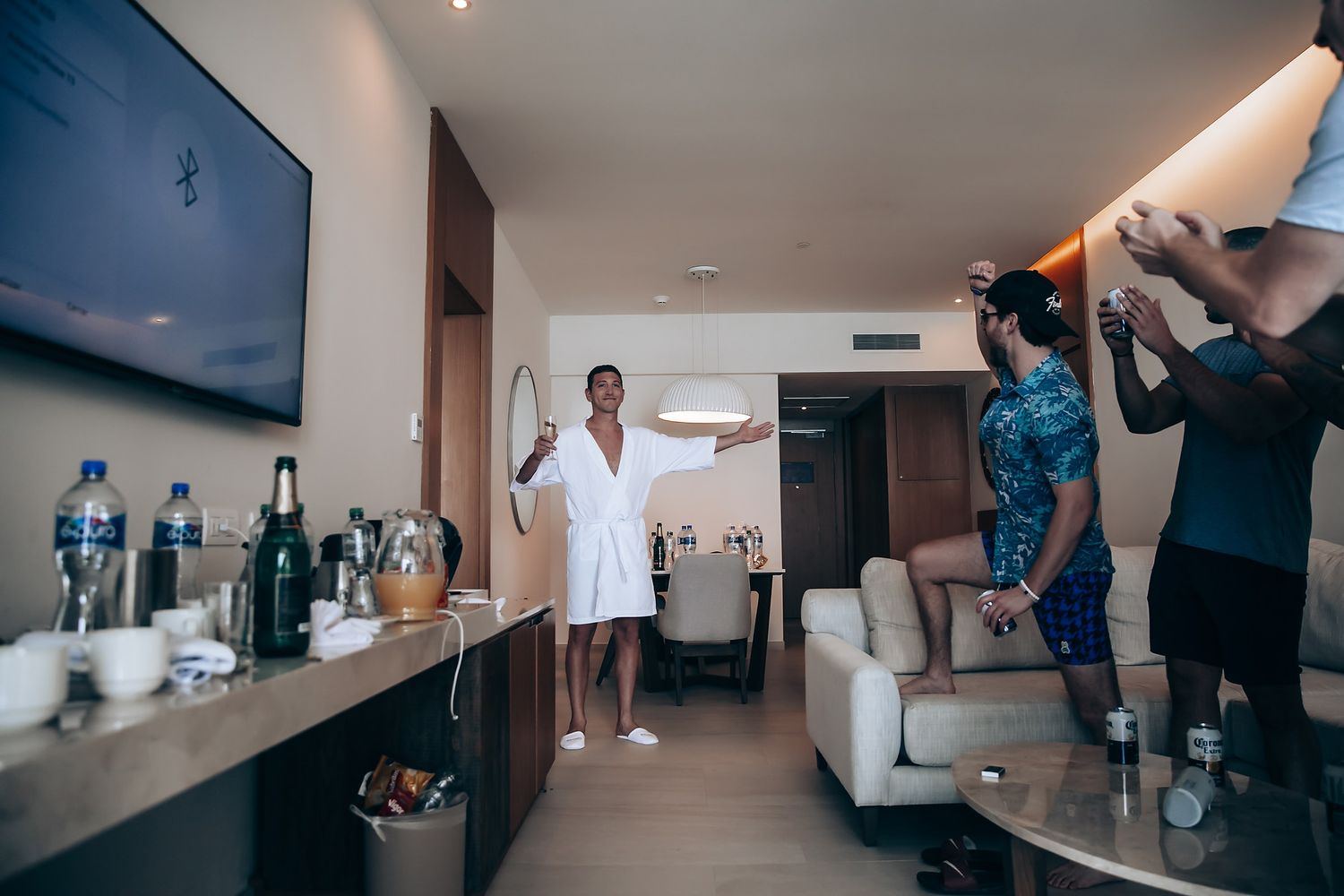 Behind the scenes photo shoot in a modern hotel room with camera operator filming in a luxurious suite.