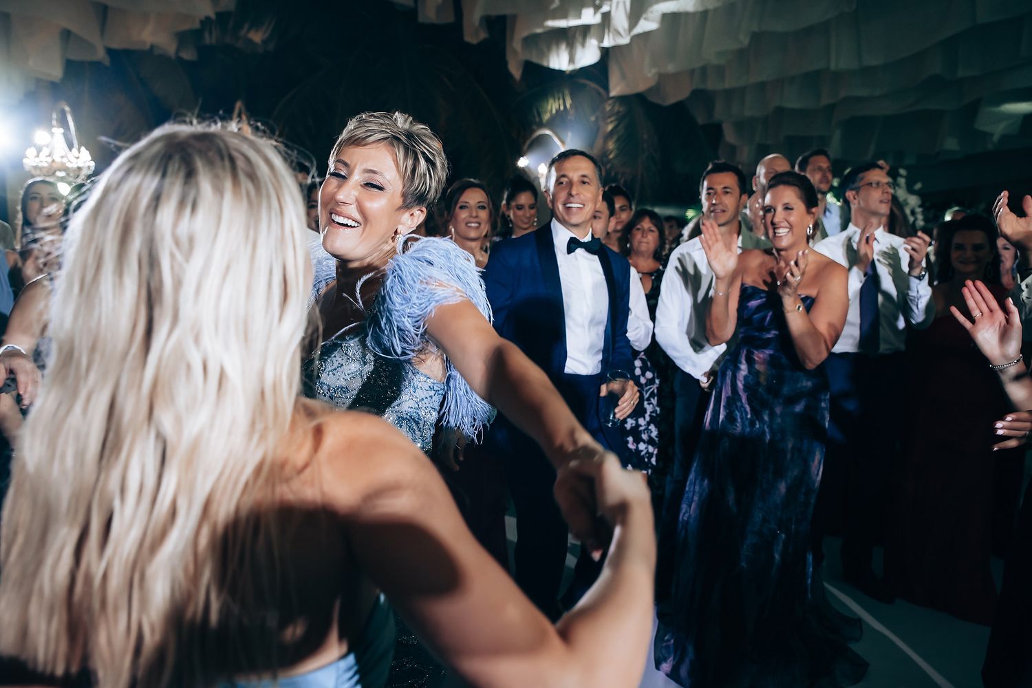 Wedding reception dance party with dramatic ceiling decor and lighting effects.