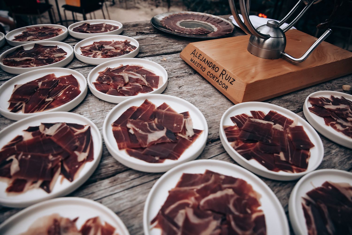Plates of sliced chocolate desserts arranged on a rustic wooden table at a catering event.