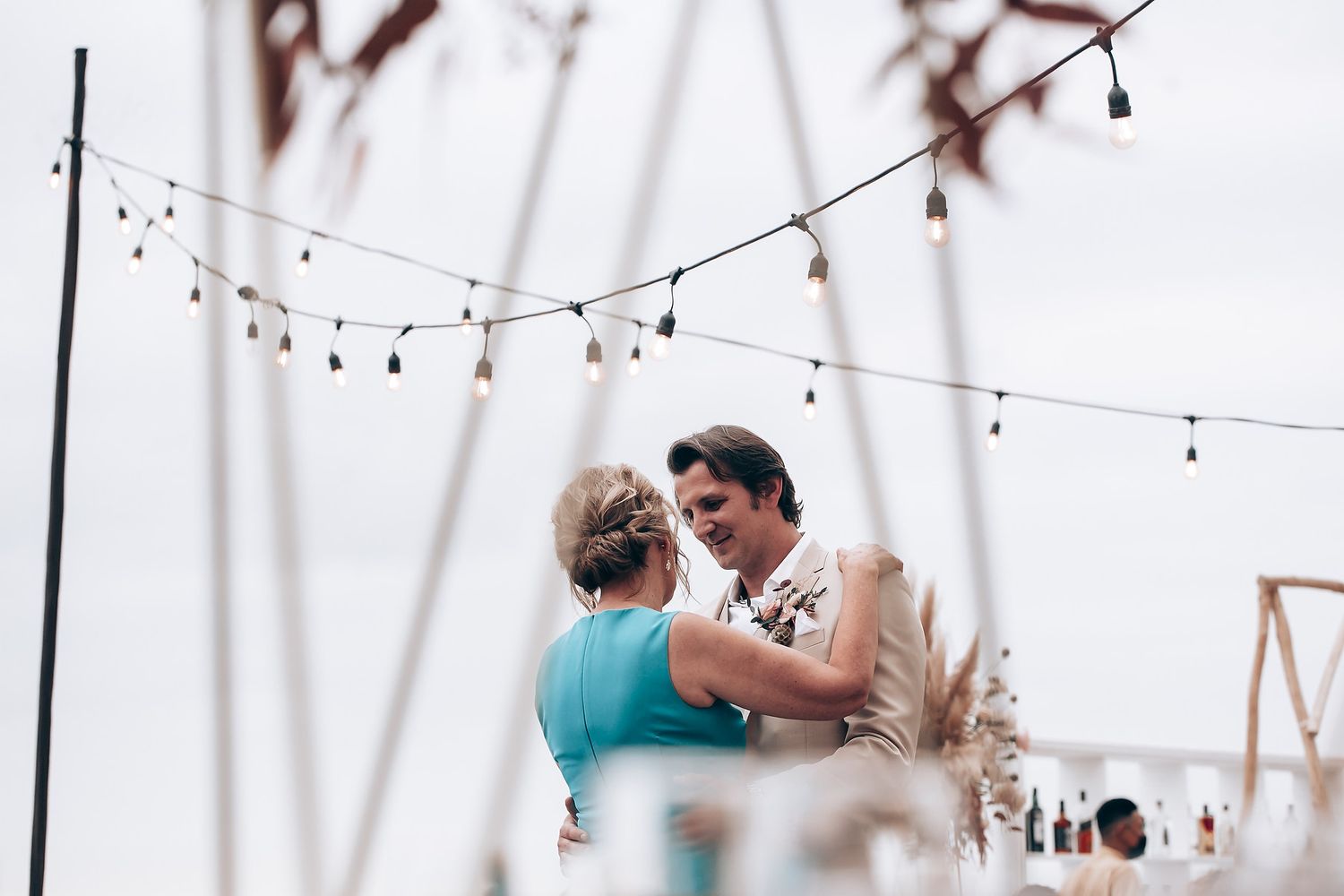 String lights hang delicately across an outdoor wedding venue creating a romantic atmosphere.