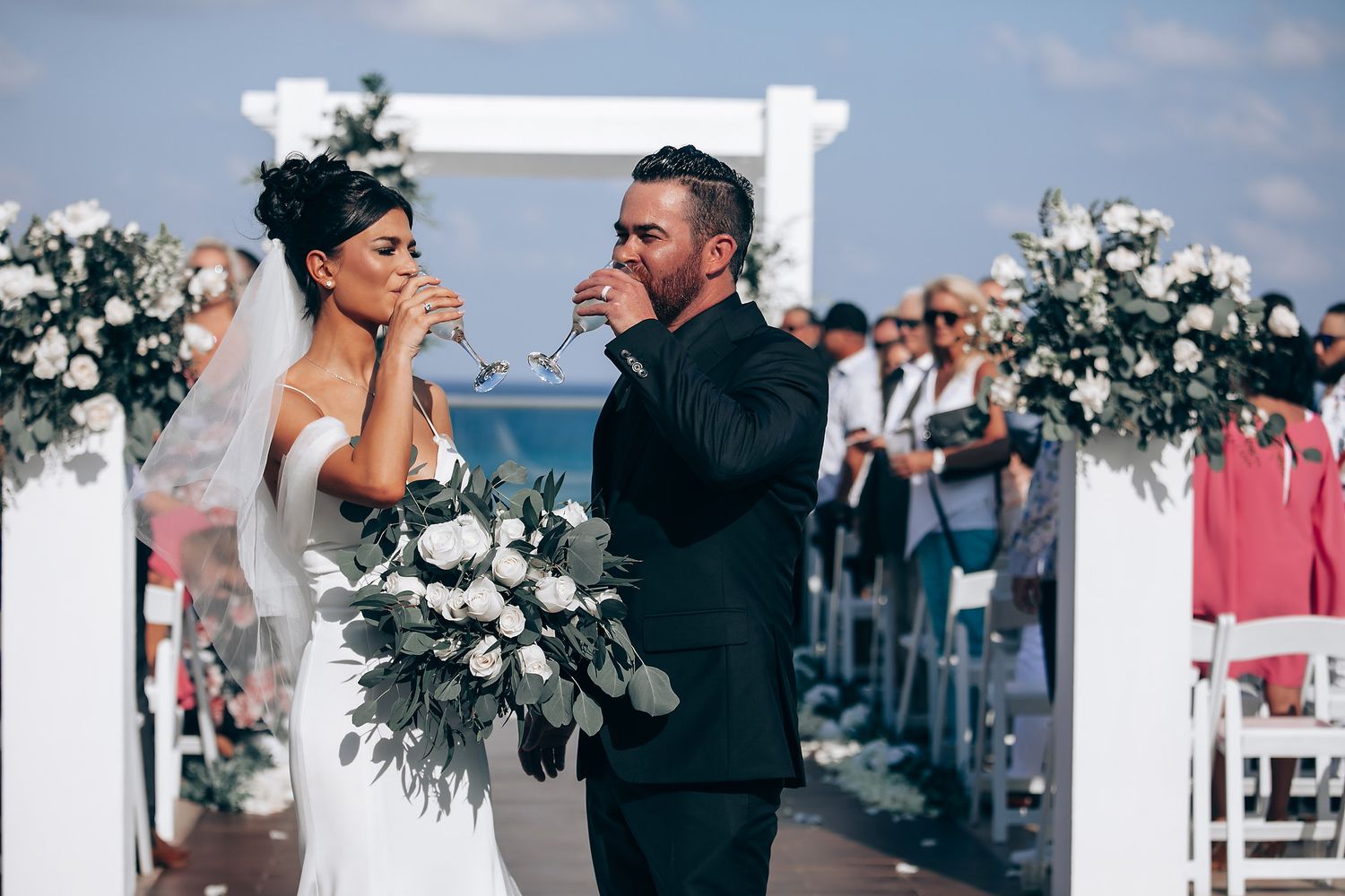 Romantic wedding celebration in modern venue with white floral decorations and natural lighting.