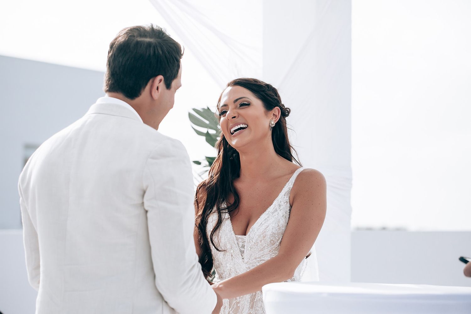 Intimate wedding moments captured in bright white setting with elegant decor.