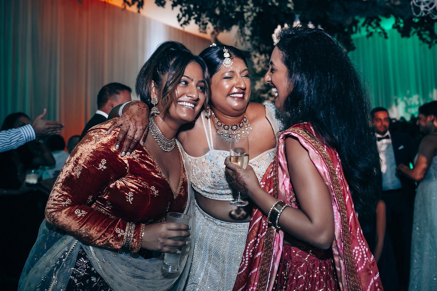 Festive wedding reception moment with guests laughing and celebrating together.