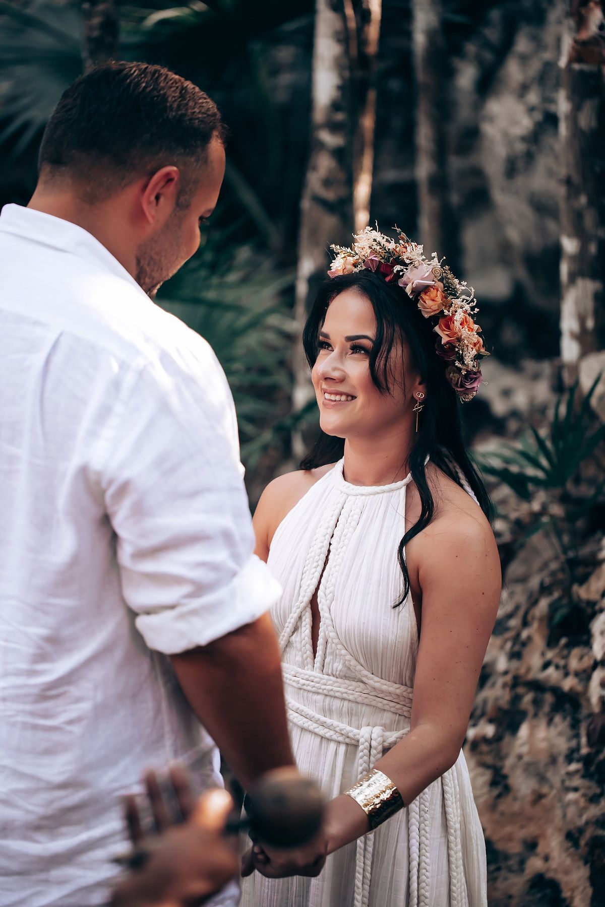 A couple shares an intimate moment during their forest wedding ceremony.
