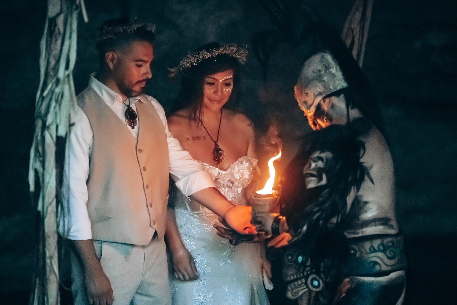 A candlelit ceremony takes place in a dark atmospheric cave setting.