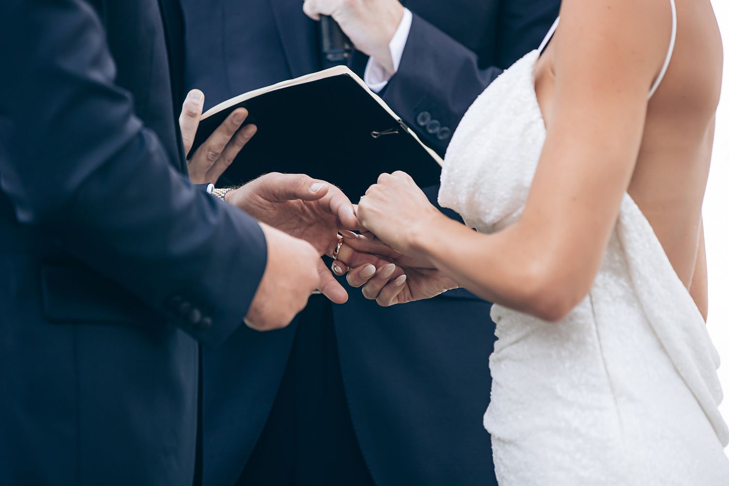 A bride and groom dance together at their wedding reception while guests watch from their tables.