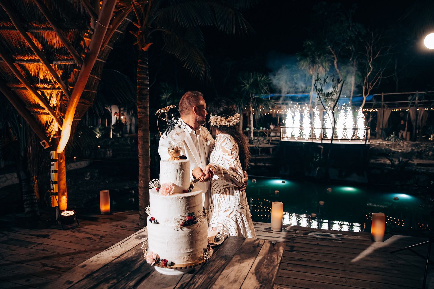 Newlyweds share their first dance at an outdoor evening reception with warm lighting and decorative lanterns.