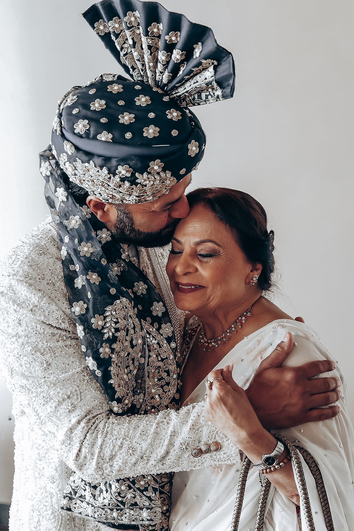 An intimate moment captured during a traditional Indian wedding ceremony with ornate attire.