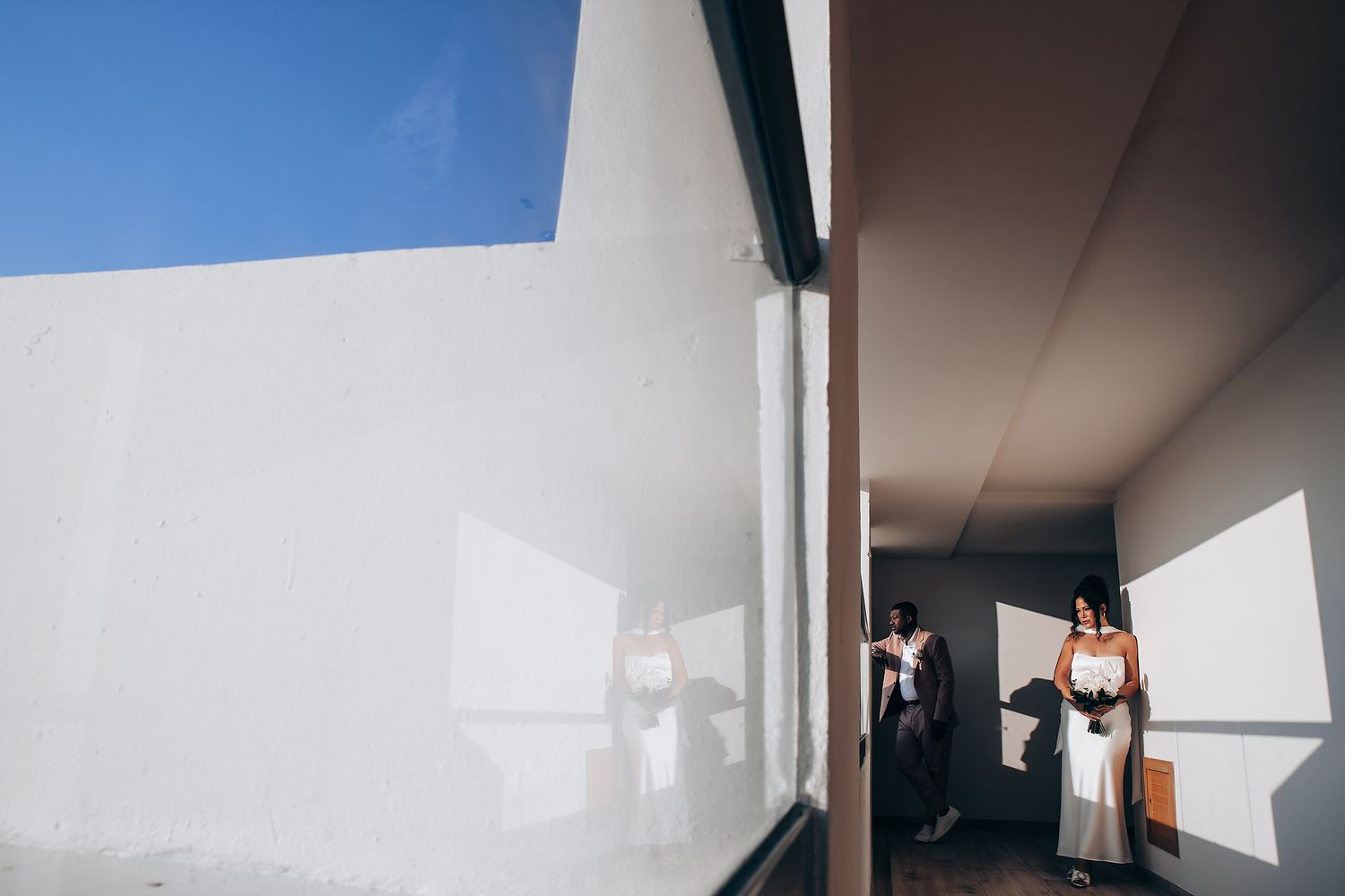 Minimalist wedding venue interior with bright blue sky visible through windows.