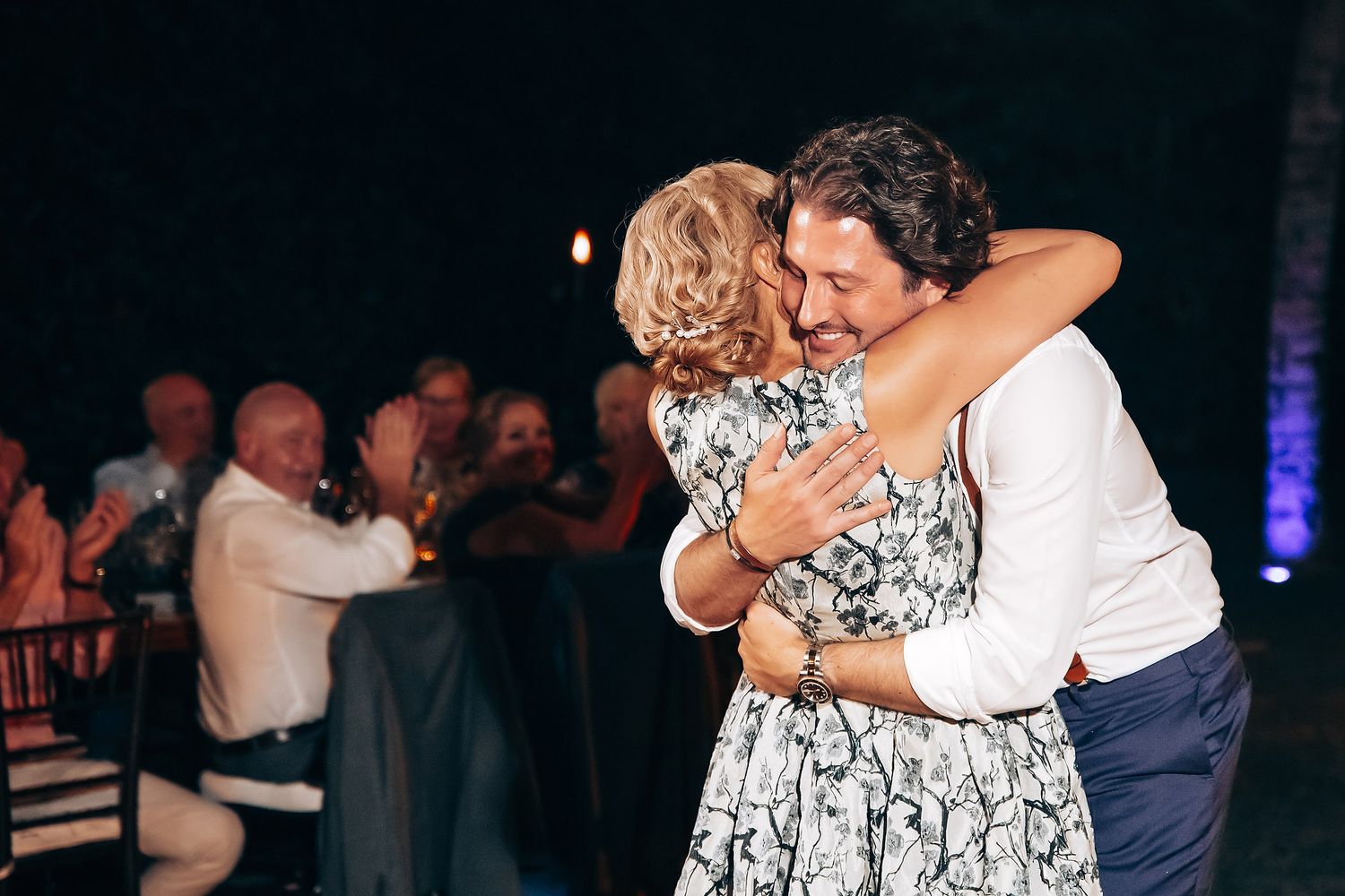 Couples dancing together during a dimly lit wedding reception celebration.