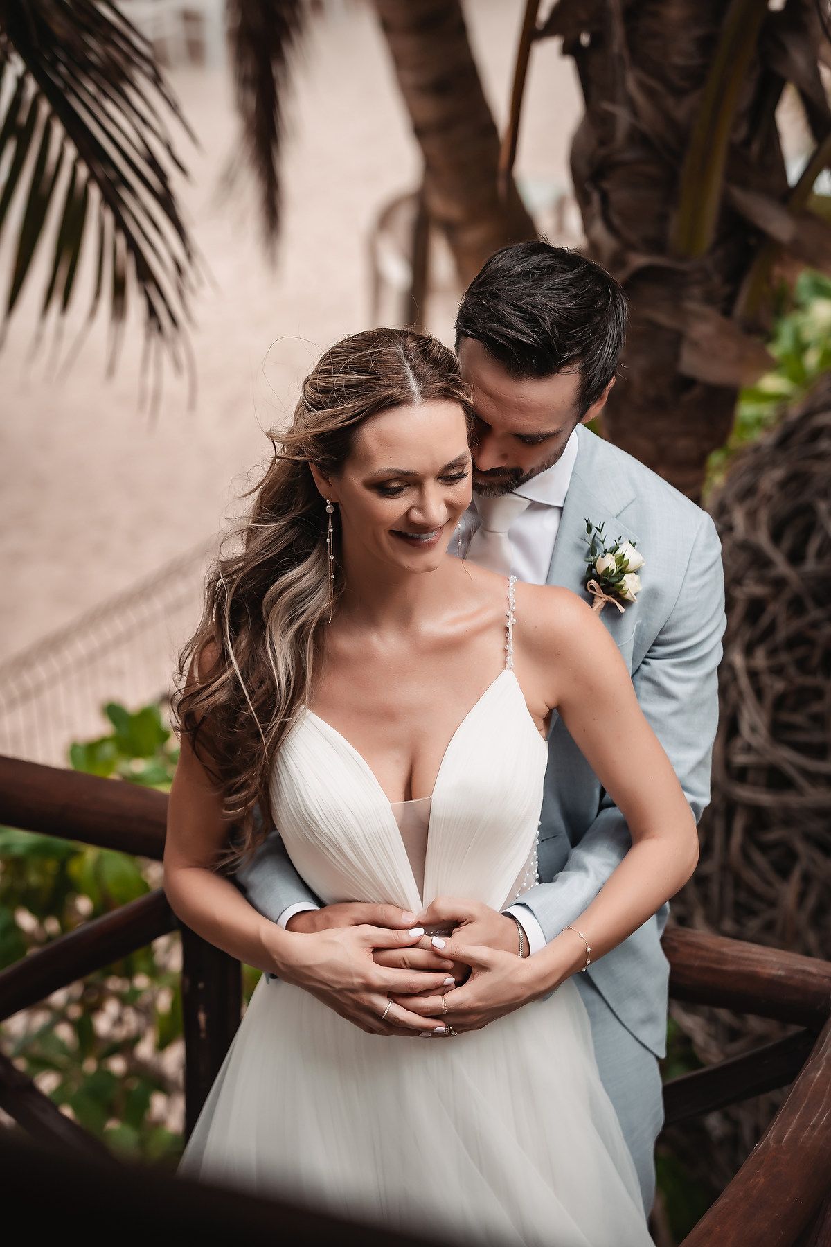 Romantic wedding portraits captured among tropical palm trees at a beach resort.