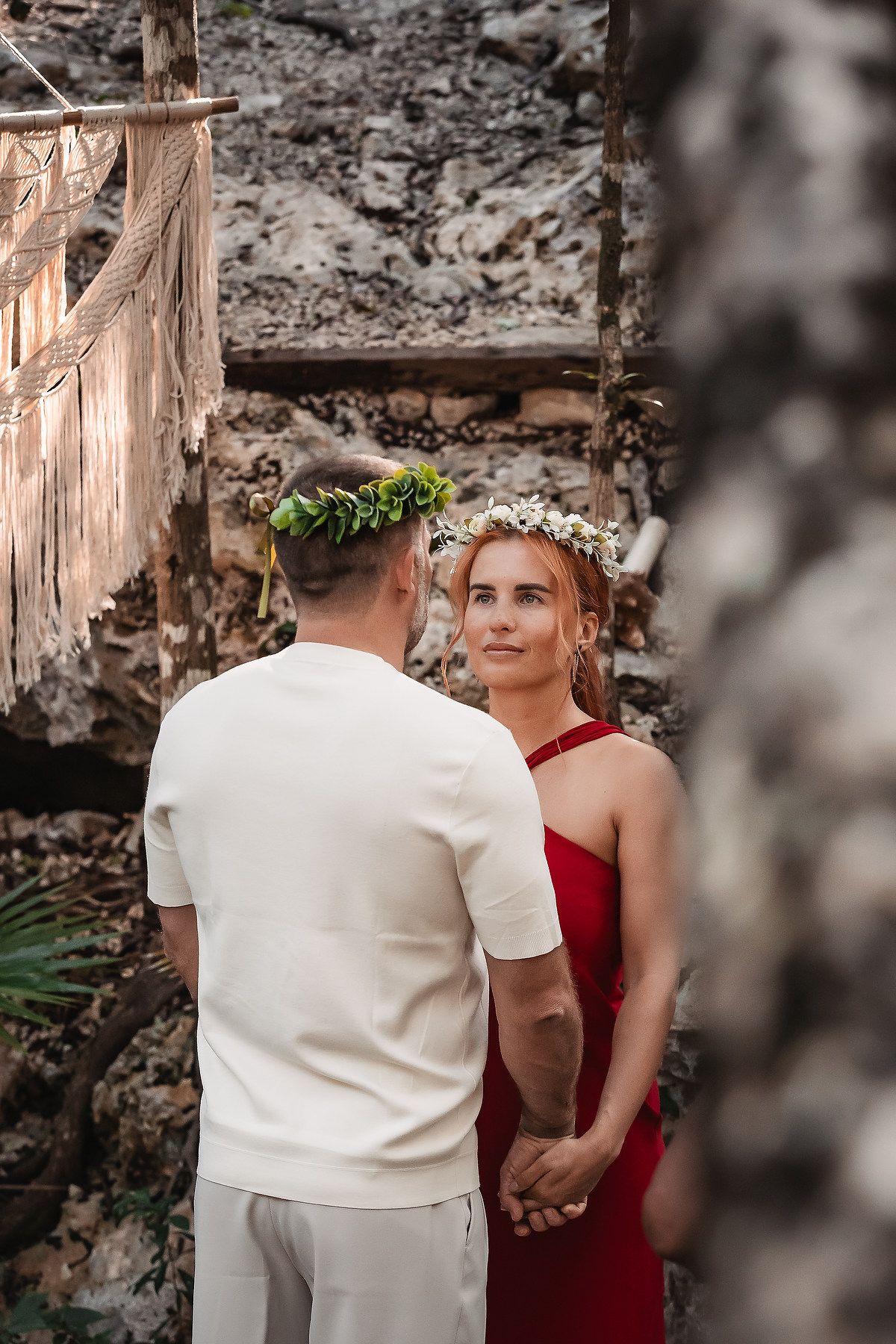 A couple shares an intimate moment during their ceremony in a natural cave setting.