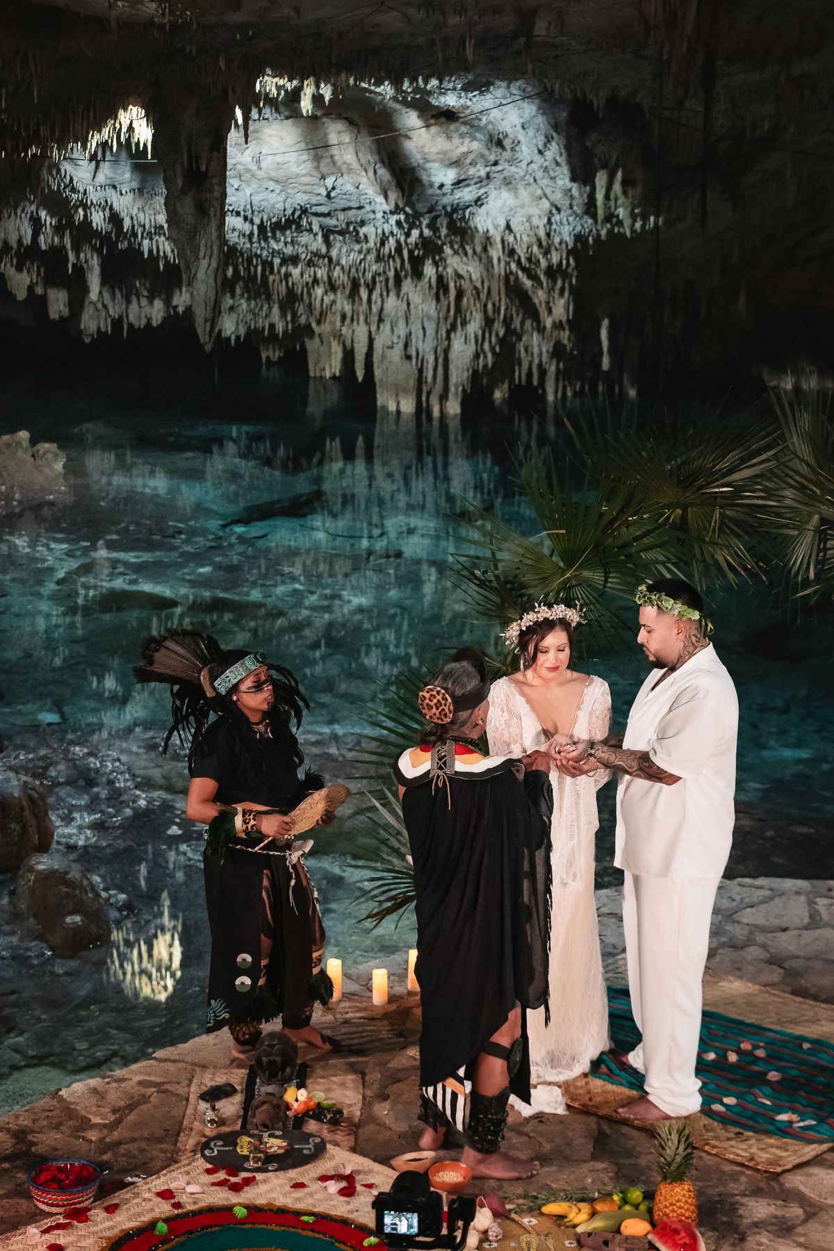 Intimate cave ceremony beside turquoise waters with candlelit decorations.