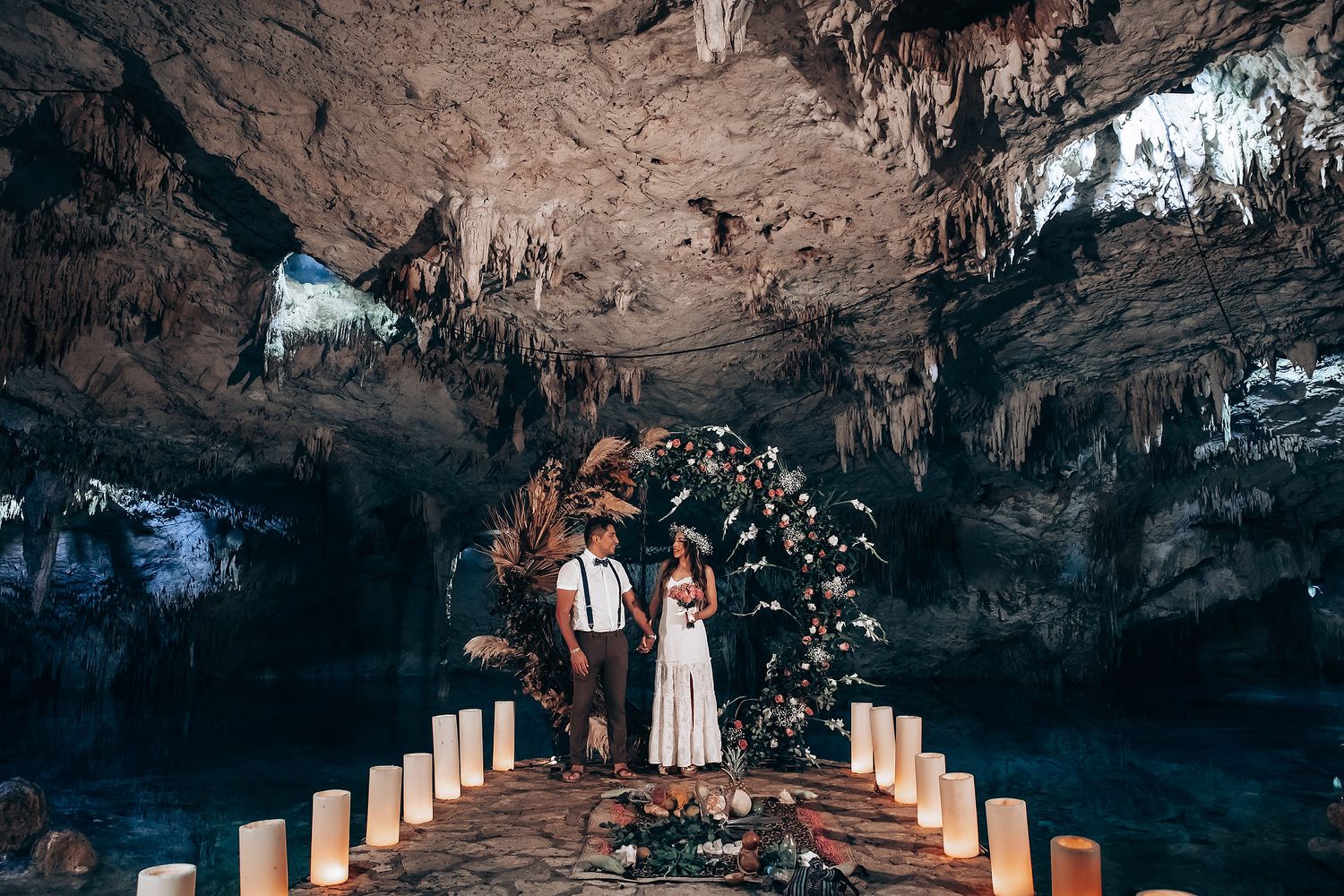 Illuminated candles line a rocky cave pathway creating a romantic ambiance in a natural underground cavern.
