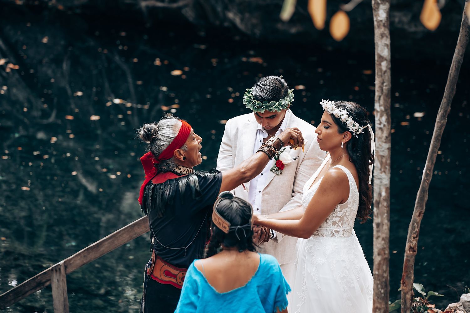 Wedding ceremony participants performing traditional rituals outdoors.