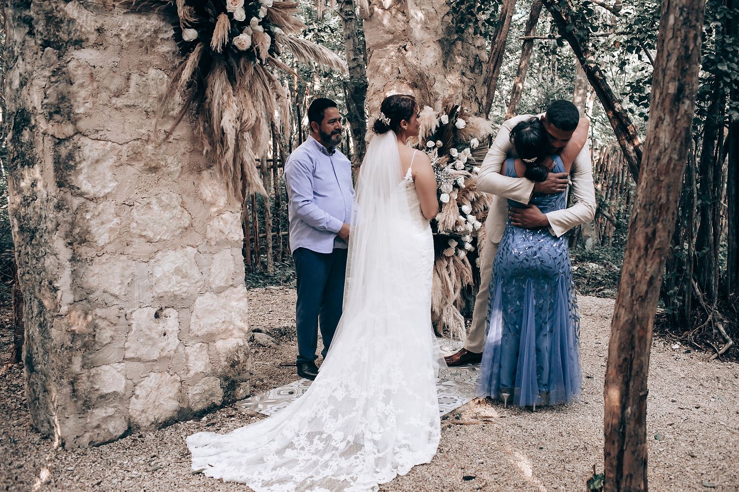 Wedding ceremony taking place in a rustic outdoor forest setting.