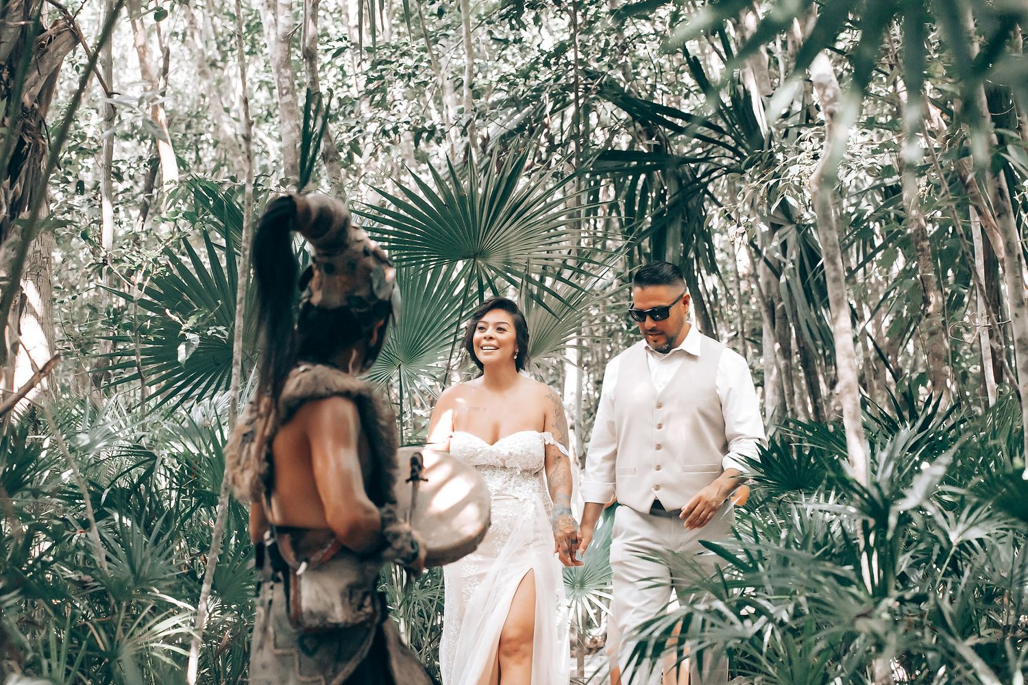 A romantic couple poses together in a lush tropical garden setting for their engagement photos.
