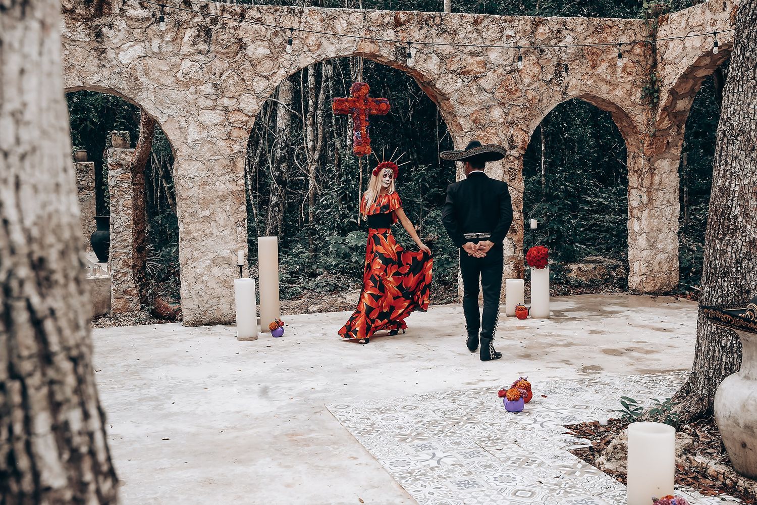 Stone archway courtyard decorated with white candles for gothic-themed wedding celebration.